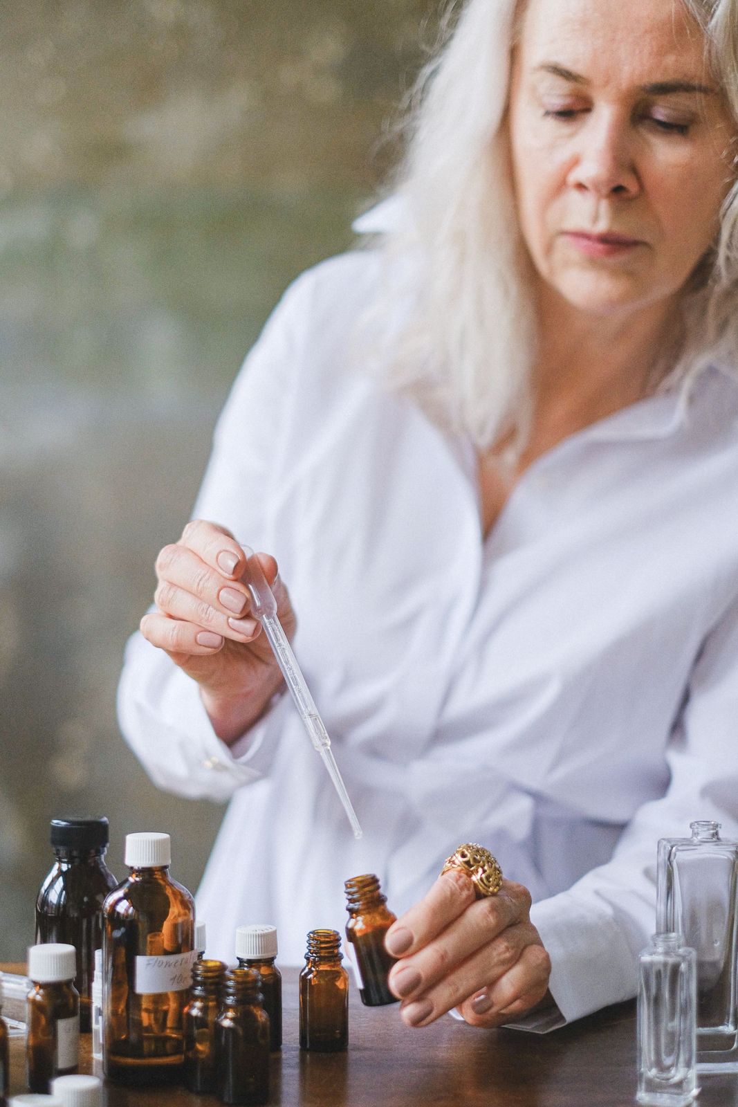 A perfumer measuring fragrance oil with a dropper
